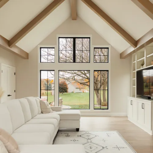 a living room with a wall of black Infinity fiberglass windows