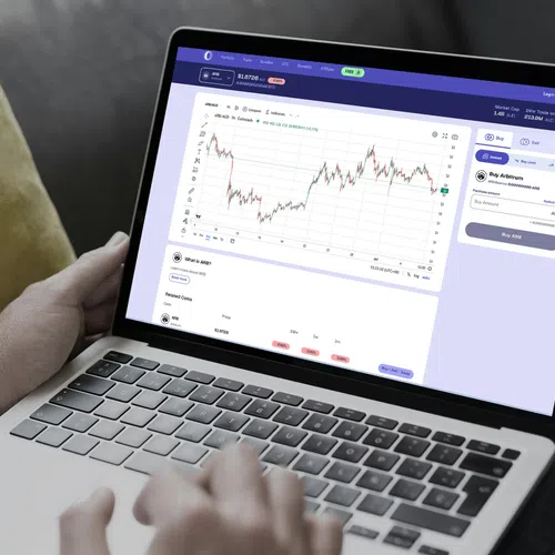 Person using laptop showing cryptocurrency trading graph and buy options on screen