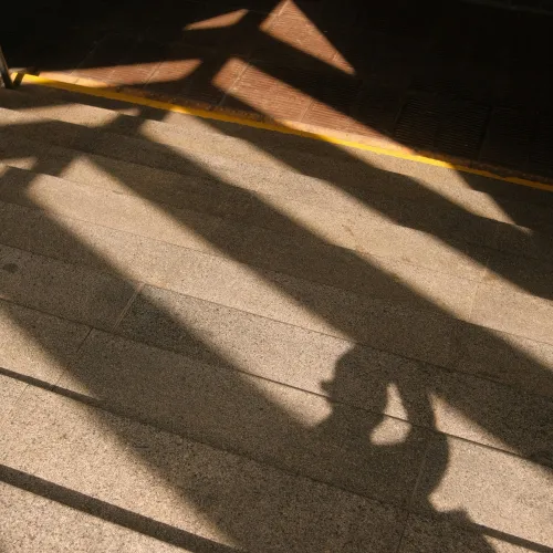a shadow of a person on a sidewalk
