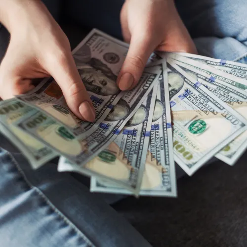 a person holding a stack of paper money
