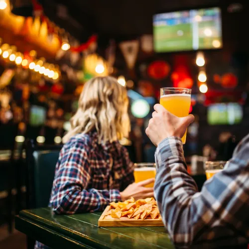 a man and a woman sitting at a table with food and drinks