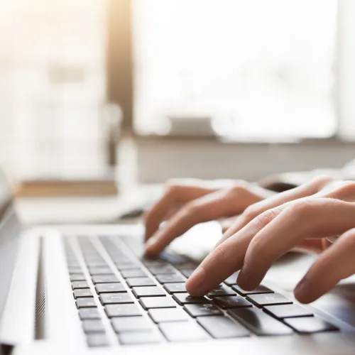 a close-up of a person typing on a laptop