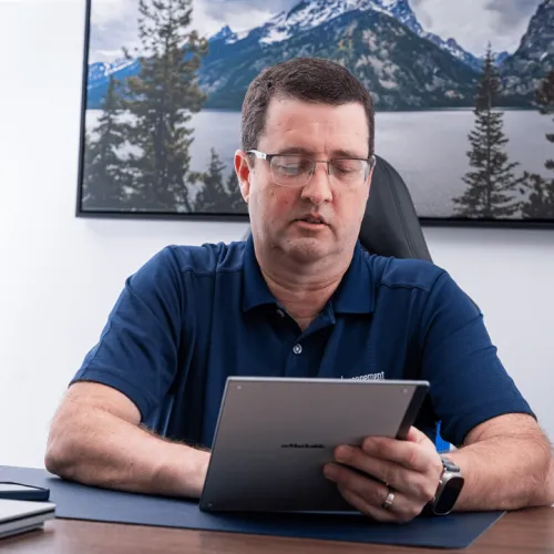 a man sitting at a desk with a laptop