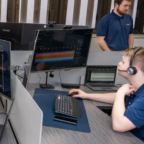 a person and a boy working on computers