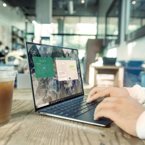 a person sitting at a table using a laptop computer