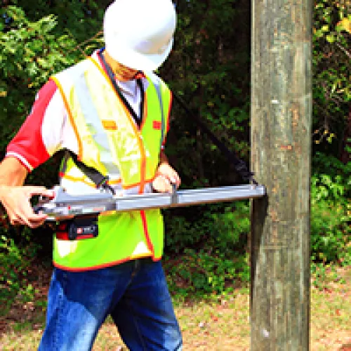 a man wearing a safety vest holding a large gun