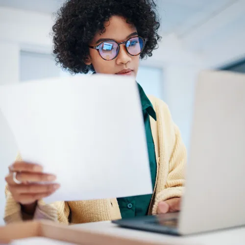 a person wearing glasses and looking at a laptop
