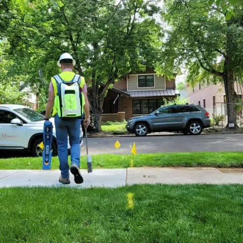 a person wearing a safety vest and holding a broom on a street