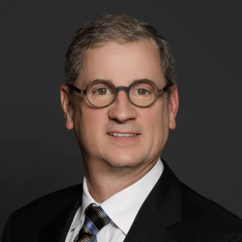 a man wearing glasses and a suit