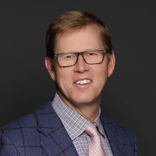 a man wearing glasses and a suit