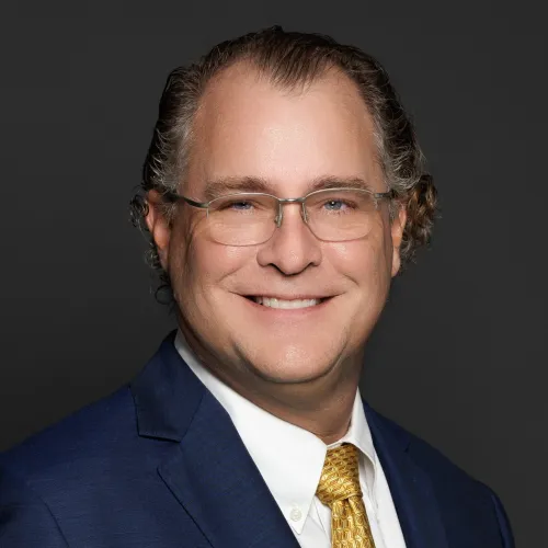 a man wearing glasses and a suit