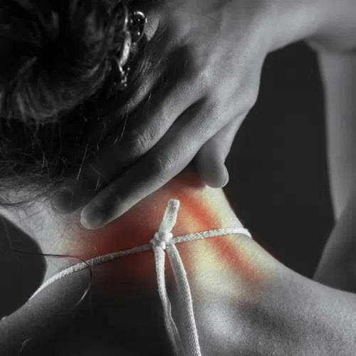 Person holding painful neck with red inflammation, highlighting neck pain and discomfort.