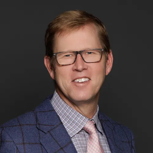 a man wearing glasses and a suit