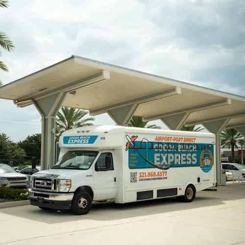 Shuttle parked under a canopy with palm trees behind