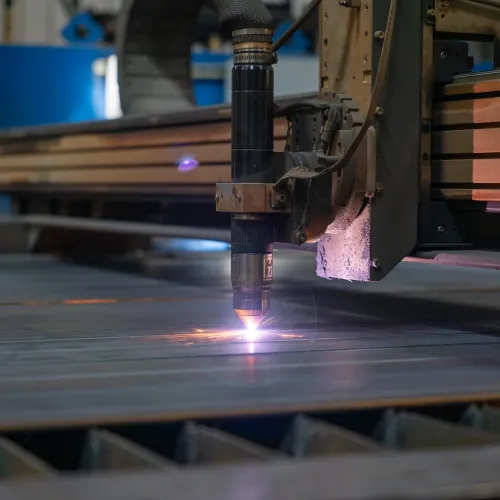 Close-up of a CNC laser cutting machine slicing through metal sheet with bright sparks flying