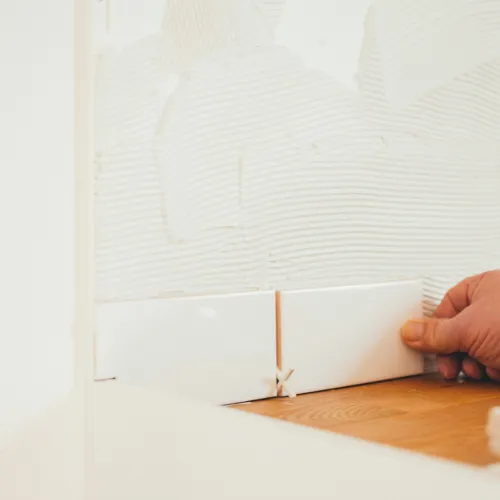 a hand holding a white sheet over a wooden table