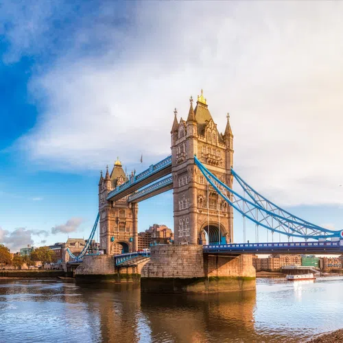 Tower Bridge in London over the River Thames on a clear day with city skyline and blue sky.