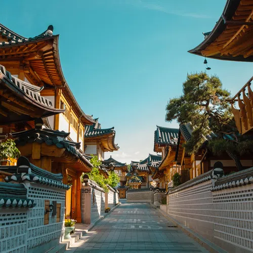 Traditional Korean hanok houses lining a quiet street under a clear blue sky on a sunny day