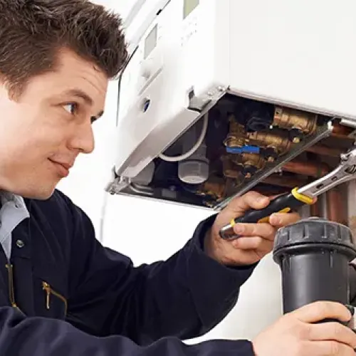Technician using wrench to repair boiler pipes in a maintenance setting, focused on plumbing work.