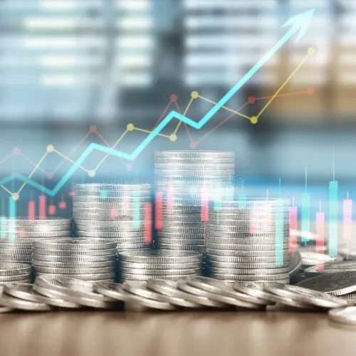 Stacked silver coins with financial charts and upward arrow symbolizing investment growth and profit increase.