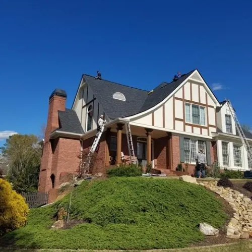 a large brick building with grass in front of a house