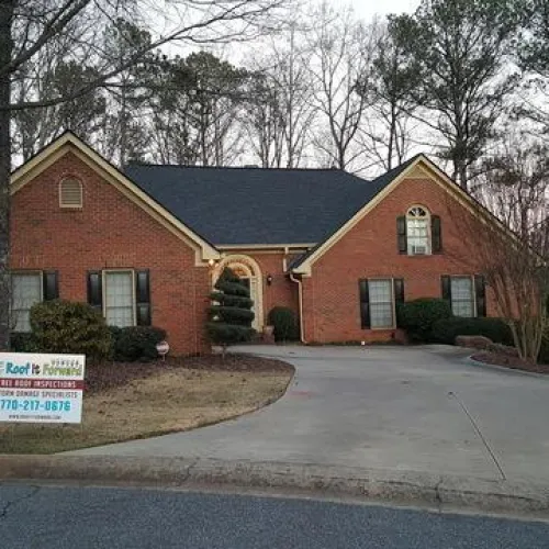 a house that has a sign on the side of a road