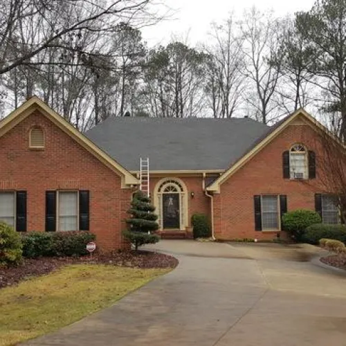 a large brick building with grass in front of a house