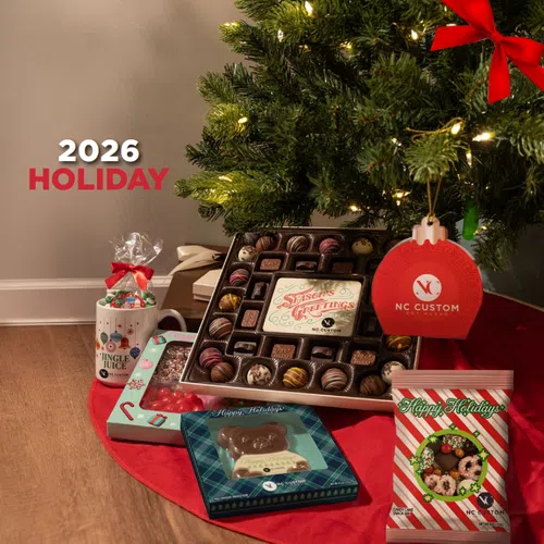Holiday gift set under Christmas tree includes chocolates, cookies, a mug with candy, and festive packaging for 2026 holiday.