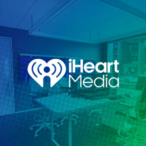 iHeart Media logo over a modern office with large windows and desks, featuring blue and green gradient overlay