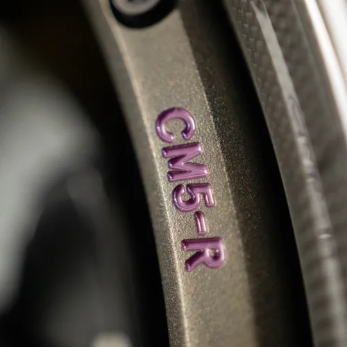 Close-up of a metallic surface with purple embossed text CM5-R on a blurred background.