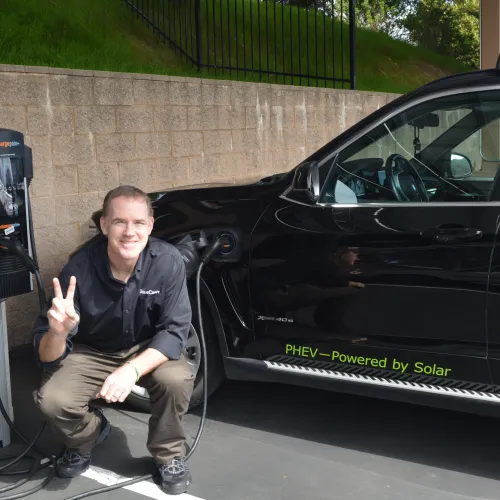 a man squatting next to a car