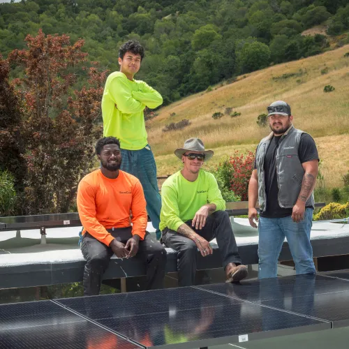 a group of men posing for a photo on a roof