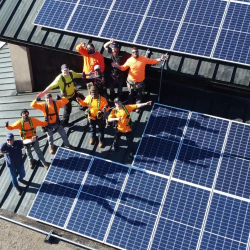 a group of people in orange shirts standing on a solar