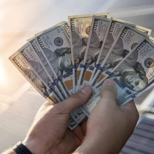 a hand holding a stack of paper money