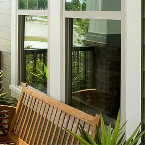 a deck with a chair and a table in front of a window
