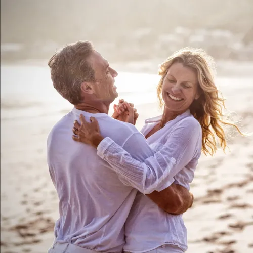 a man and a woman dancing on a beach