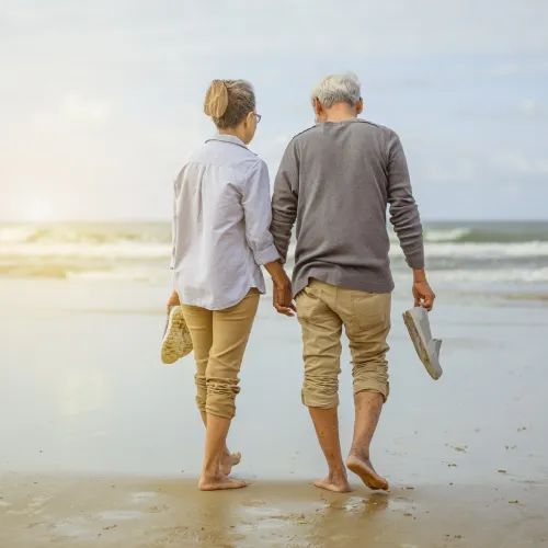 a man and woman holding hands on a beach