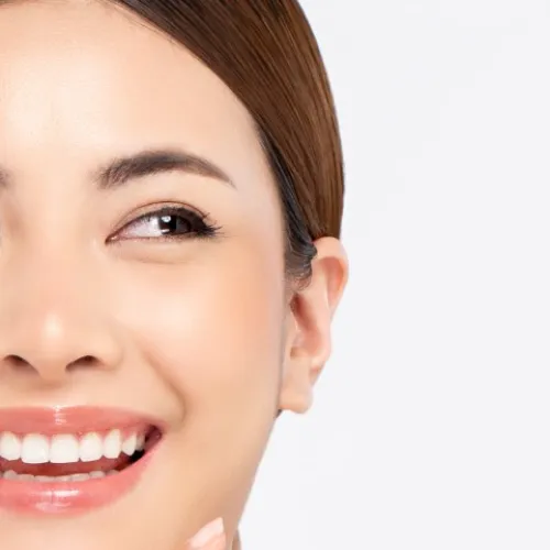 a woman smiling with her hand on her chin