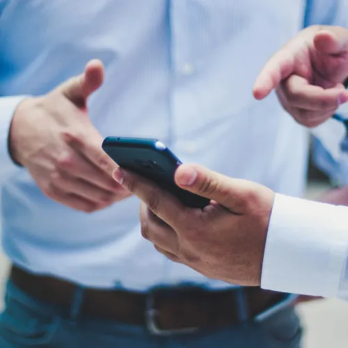 a few hands holding a smart phone
