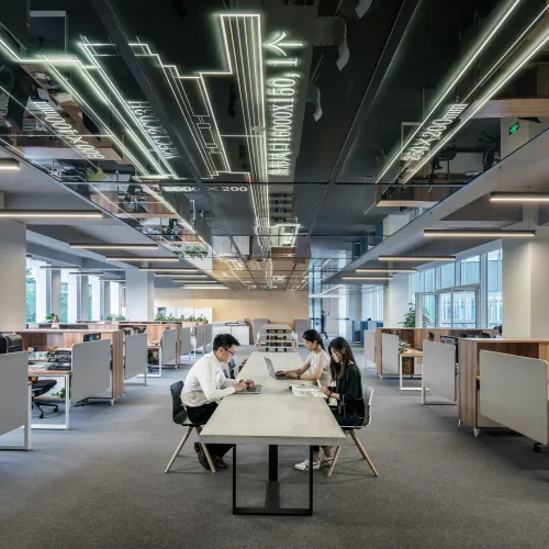 a group of people sitting at a table in a large office