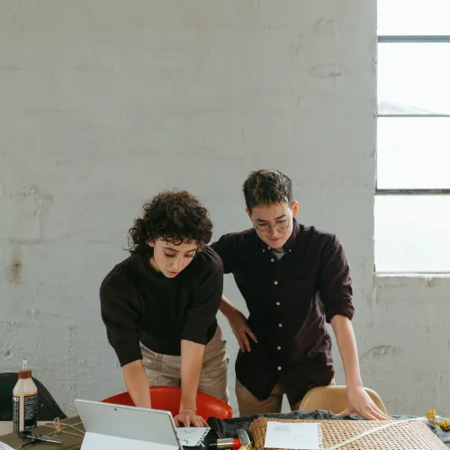 a couple of men looking at a laptop