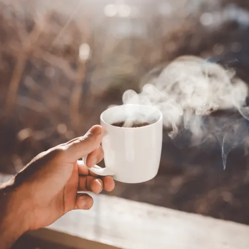 a hand holding a cup of coffee