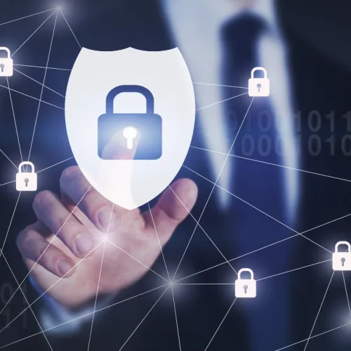 Businessman touching digital shield with lock icon representing cybersecurity and data protection network