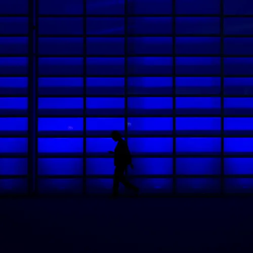 a silhouette of a person walking in front of a large window