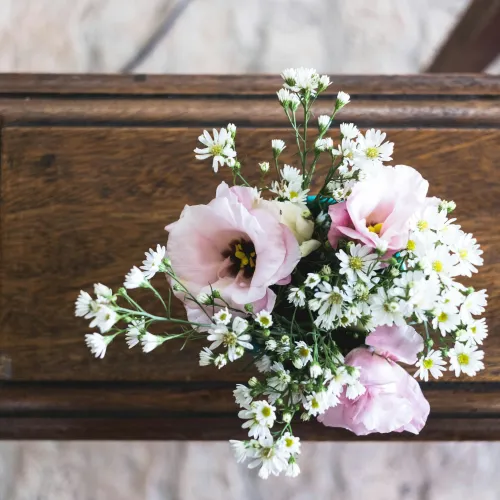 Professional confident woman in black suit and white blouse standing with arms crossed against white background.