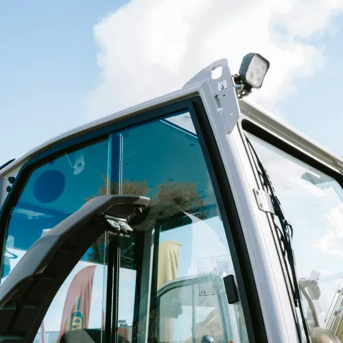 Close-up view of a modern construction vehicle cabin with clear glass windows and exterior lights