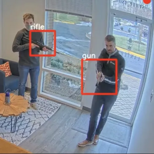 Three men in an office, two holding guns and one holding a rifle, with annotations highlighting the weapons.