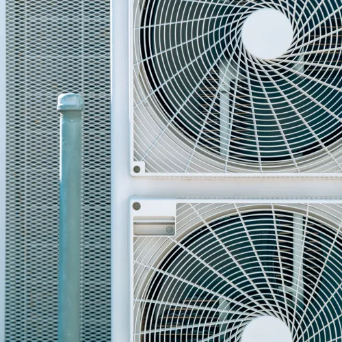 Close-up of cooling unit with two large fans and mesh panels, showcasing modern air conditioning technology.