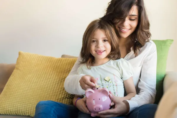 mother and daughter saving money in a piggy bank