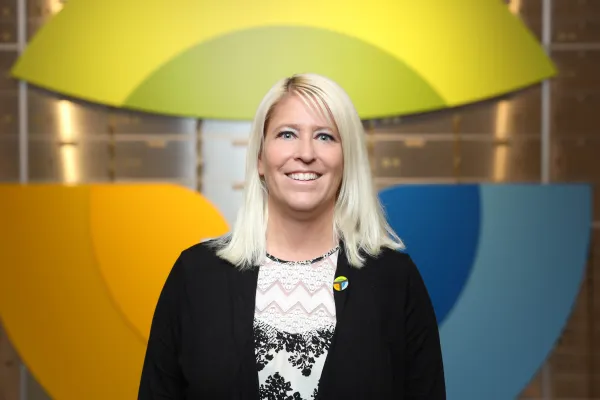 a person smiling in front of a yellow umbrella